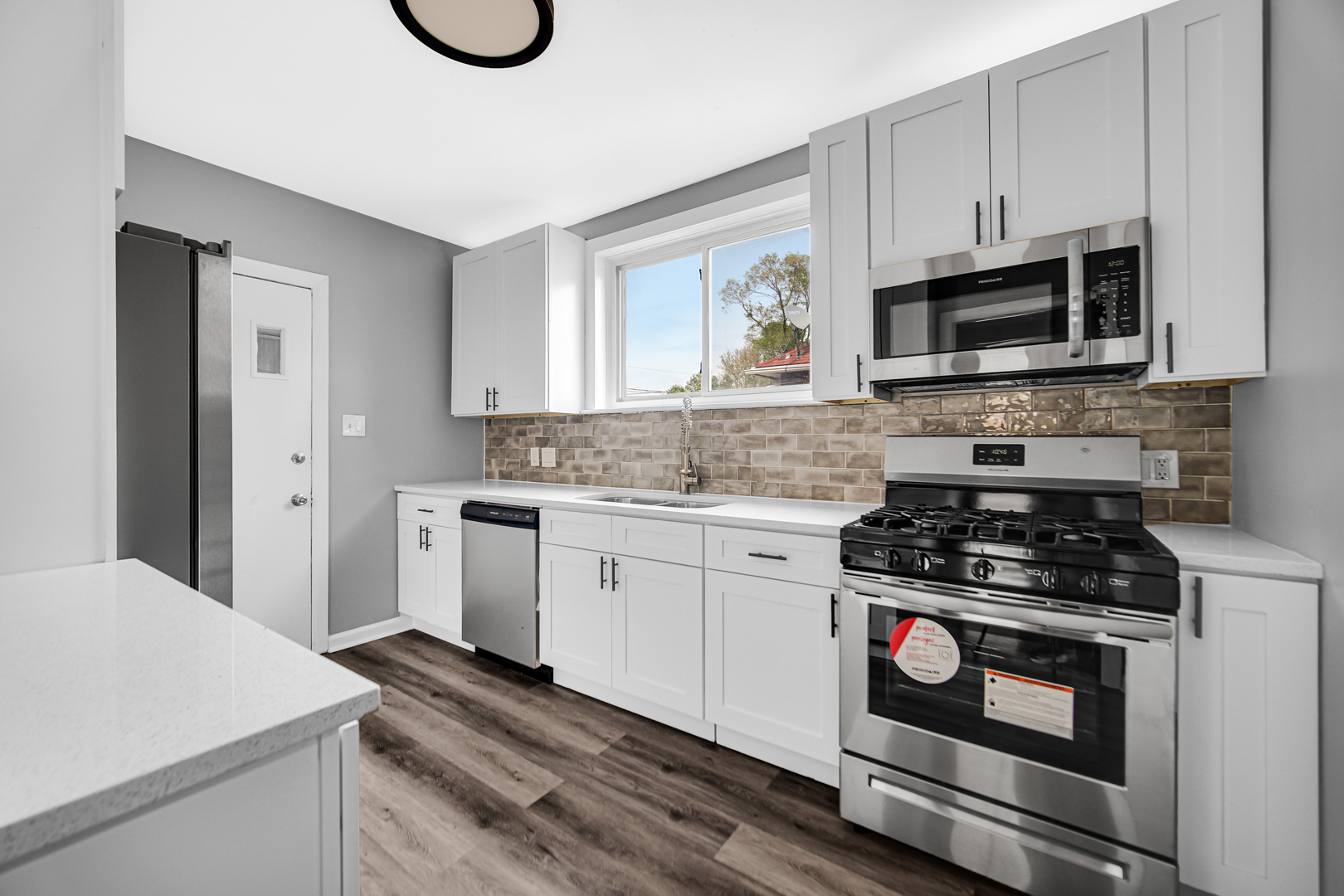 248 Ruth Street Calumet City, IL 60409 - Photo 9 of 19 a kitchen with granite countertop a stove a sink and a microwave