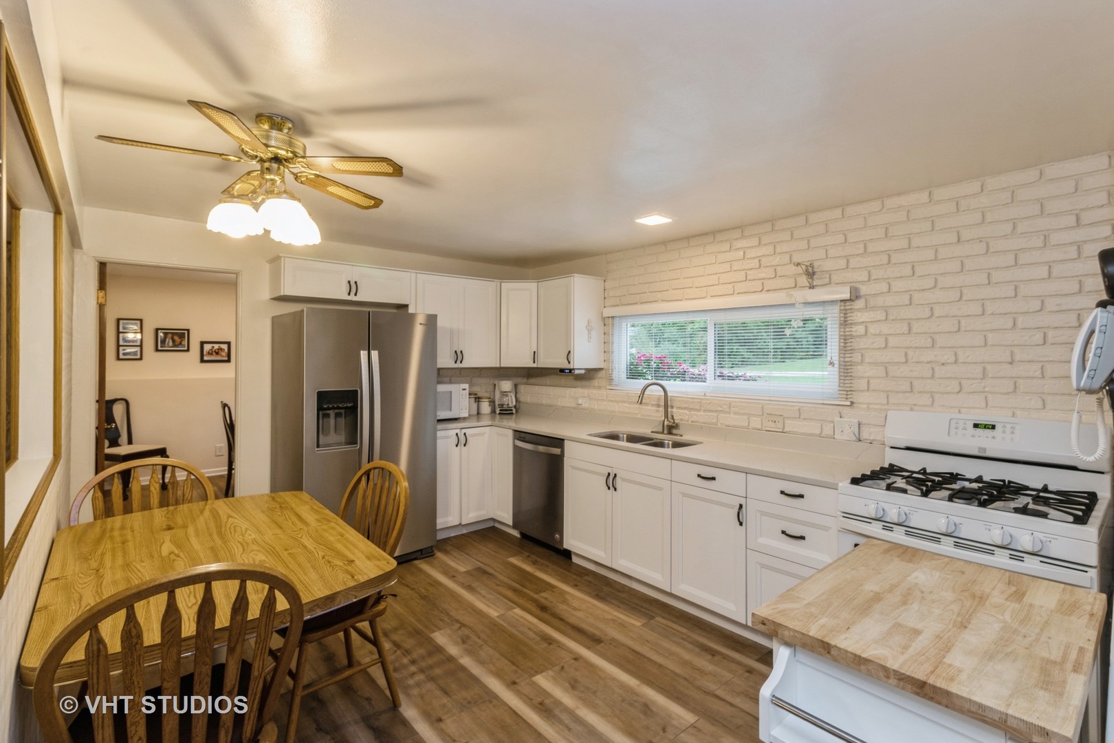 102 Big Oaks Road Streamwood, IL 60107 - Photo 3 of 11 a kitchen with stainless steel appliances granite countertop a stove a sink dishwasher and a refrigerator with wooden floor