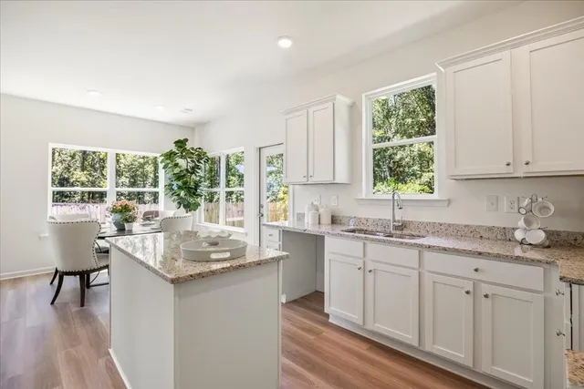 a kitchen with kitchen island granite countertop a sink and cabinets