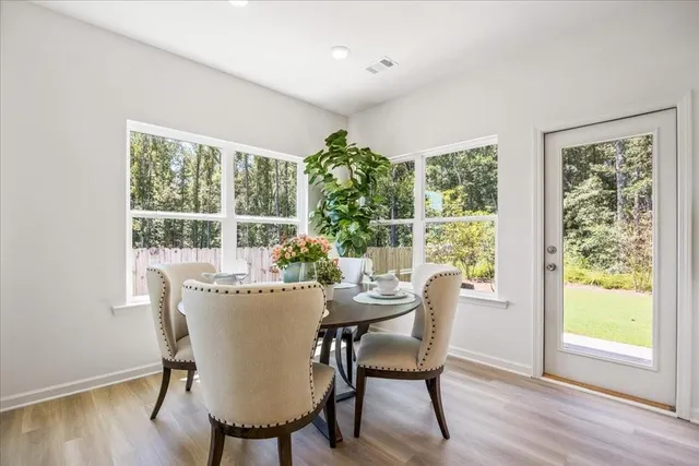 a dining room with furniture window outside view and wooden floor