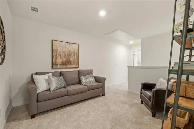 a living room with furniture and a potted plant