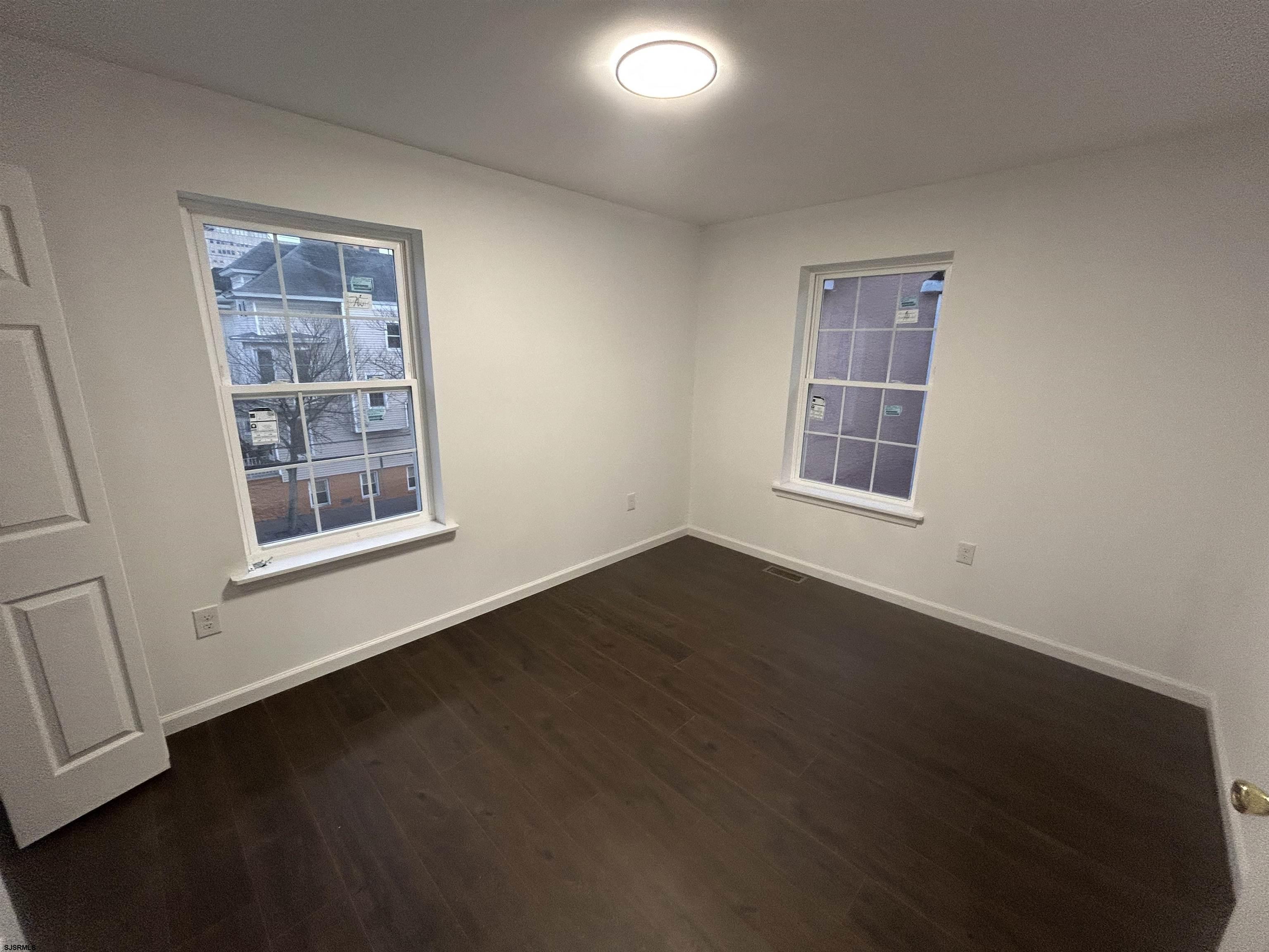 2821 Arctic Avenue, Unit 3 Atlantic City, NJ 08401 - Photo 8 of 11 a view of an empty room with a window and wooden floor