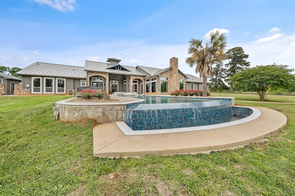 20389 County Road 178 Flint, TX 75762 - Photo 35 of 40 Infinity-edge swimming pool with blue mosaic tile detailing and integrated spa