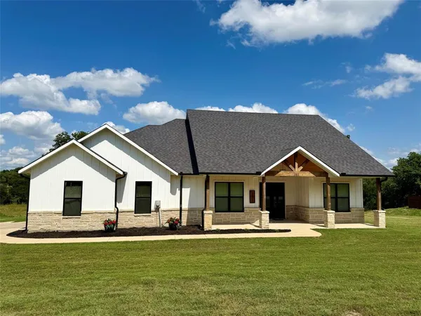 a front view of a house with a garden and yard