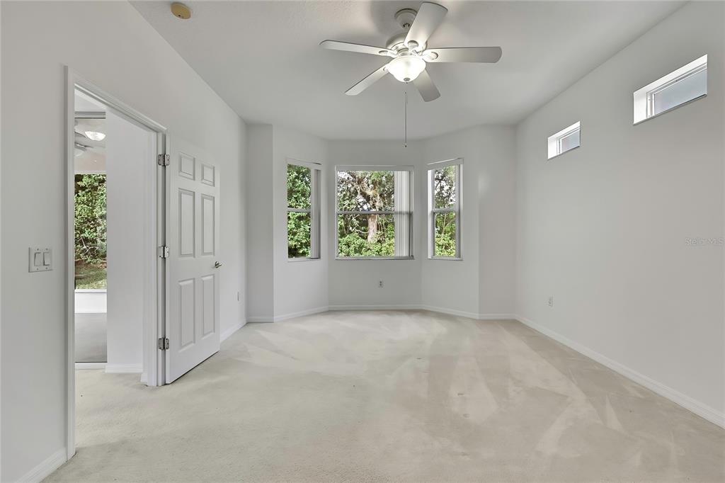 8049 Sanguinelli Road Land O Lakes, FL 34637 - Photo 16 of 45 an empty room with windows and ceiling fan