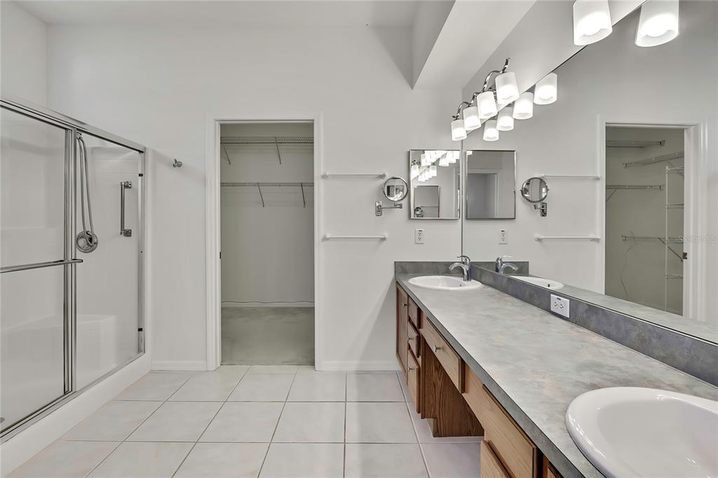 8049 Sanguinelli Road Land O Lakes, FL 34637 - Photo 20 of 45 a spacious bathroom with a granite countertop sink a toilet a mirror and shower