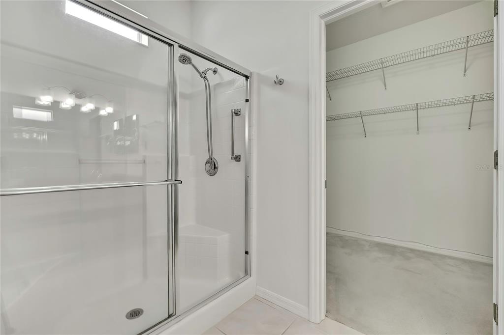 8049 Sanguinelli Road Land O Lakes, FL 34637 - Photo 23 of 45 a bathroom with a glass shower door