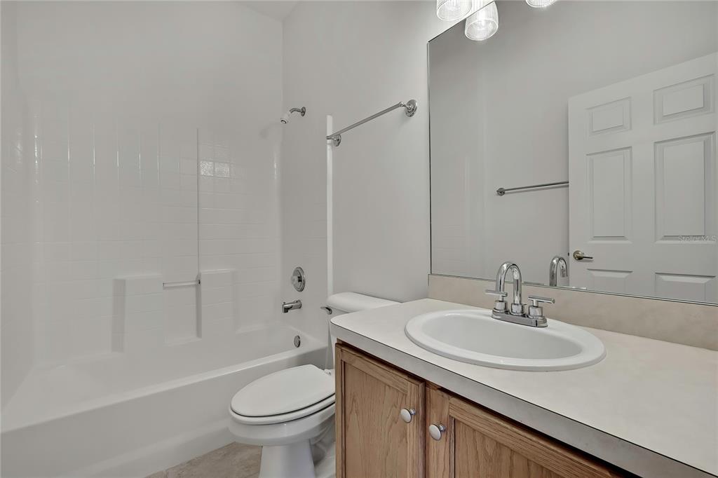 8049 Sanguinelli Road Land O Lakes, FL 34637 - Photo 30 of 45 a bathroom with a sink toilet and a mirror