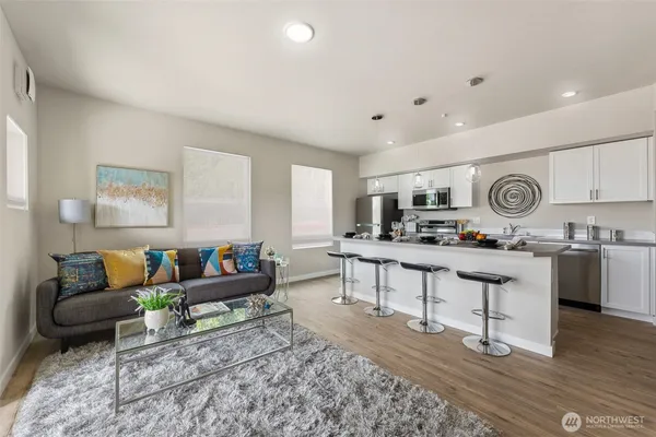 a living room with furniture and view of kitchen