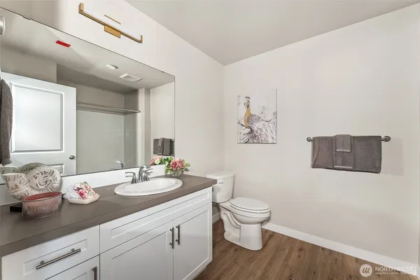 a bathroom with a granite countertop sink a toilet and a mirror