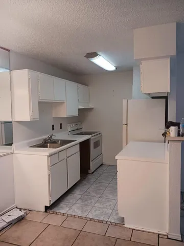 a kitchen with a sink stove and cabinets