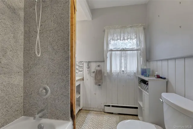 a bathroom with a granite countertop sink mirror and toilet