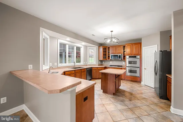 a kitchen with stainless steel appliances a sink stove and refrigerator