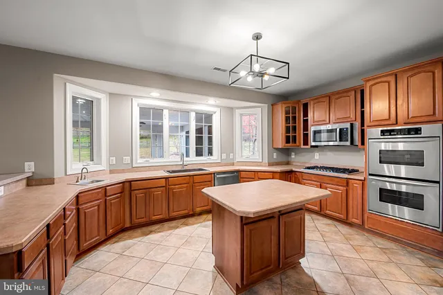 a kitchen with a stove a sink dishwasher and wooden cabinets