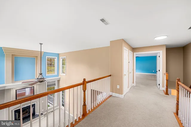 a view of a livingroom with a chandelier fan and windows