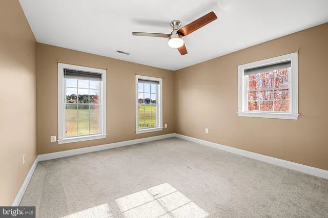 a view of a livingroom with a ceiling fan and window