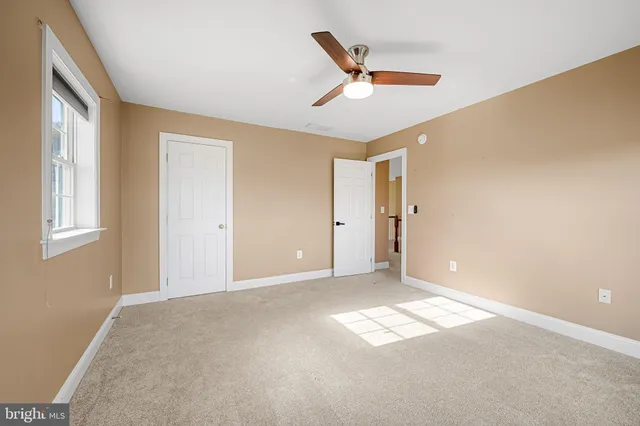 a view of an empty room with a ceiling fan