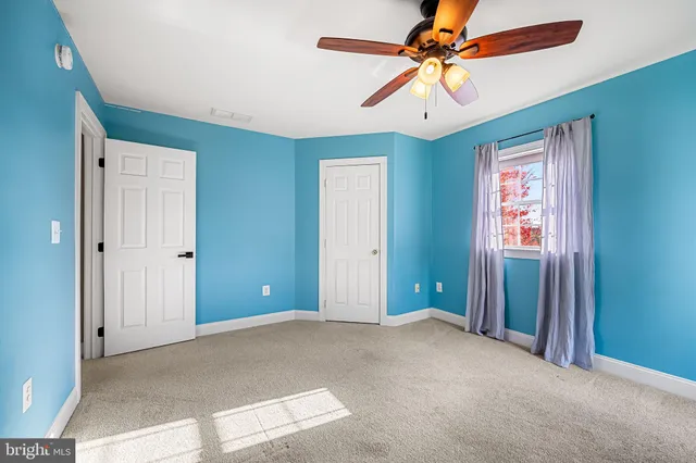 a view of a livingroom with a ceiling fan and window