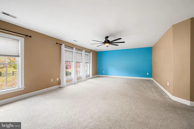 a view of a big room with windows and chandelier