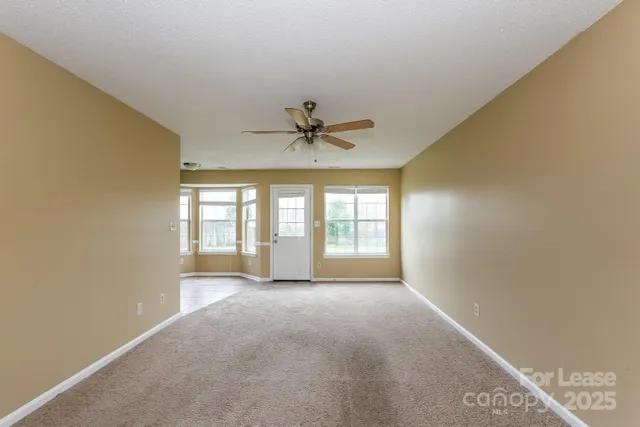 a view of a livingroom with a ceiling fan and window