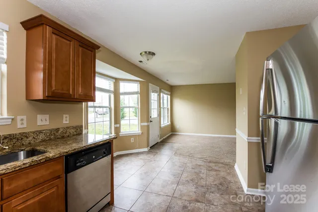 a kitchen with stainless steel appliances granite countertop a refrigerator and a sink