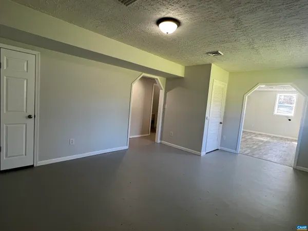an empty room with closet and mirror