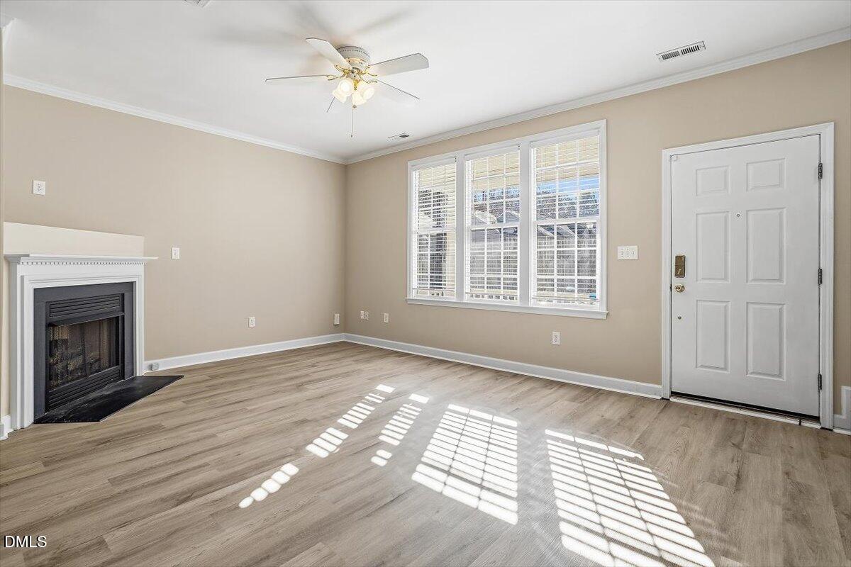 2220 Trailwood Valley Circle Raleigh, NC 27603 - Photo 12 of 37 wooden floor fireplace and windows in an empty room