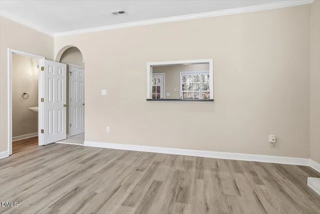 a view of an empty room with wooden floor