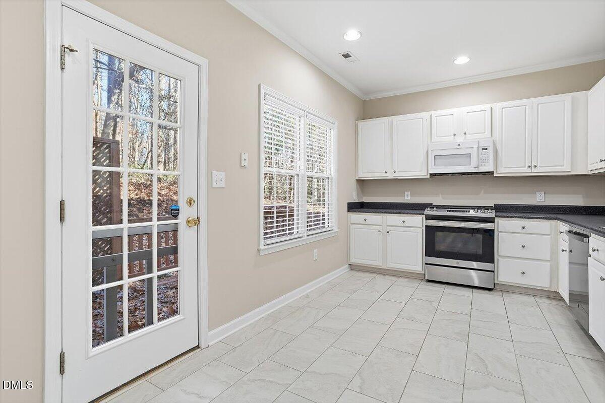 2220 Trailwood Valley Circle Raleigh, NC 27603 - Photo 18 of 37 a kitchen with stainless steel appliances a stove sink and cabinets