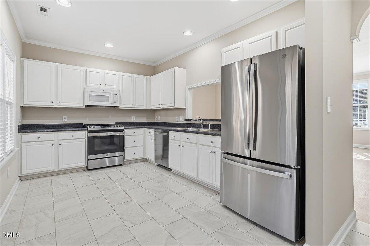 2220 Trailwood Valley Circle Raleigh, NC 27603 - Photo 19 of 37 a kitchen with stainless steel appliances cabinets and a refrigerator