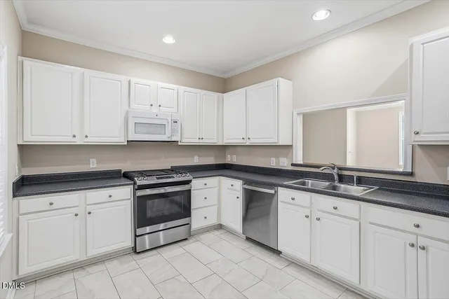 a kitchen with white cabinets and white appliances