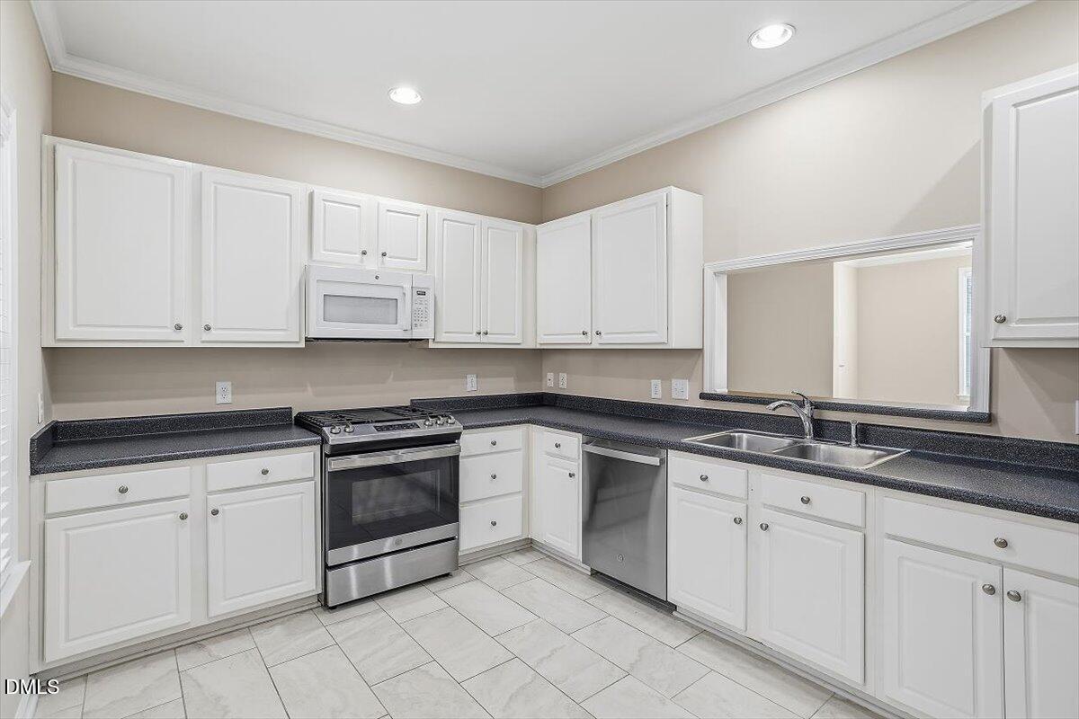 2220 Trailwood Valley Circle Raleigh, NC 27603 - Photo 21 of 37 a kitchen with white cabinets stainless steel appliances and a sink