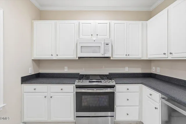 a kitchen with granite countertop white cabinets and a sink