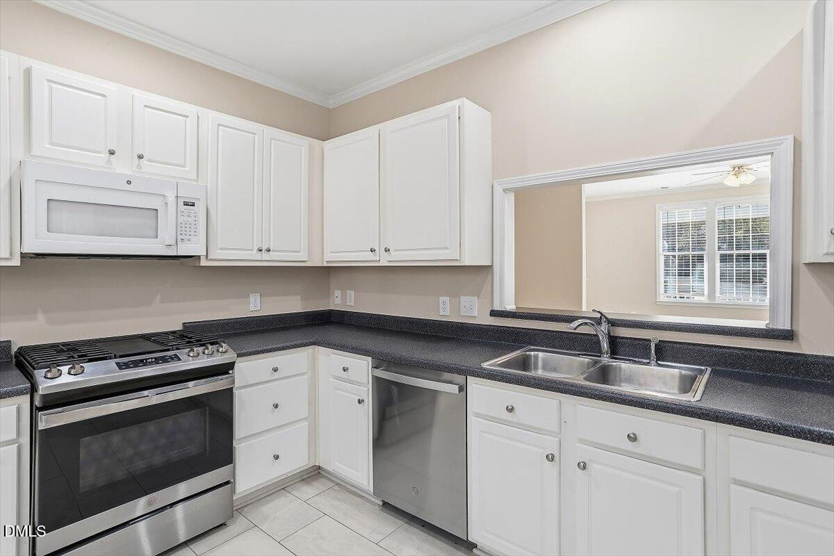 2220 Trailwood Valley Circle Raleigh, NC 27603 - Photo 23 of 37 a kitchen with granite countertop white cabinets and a sink