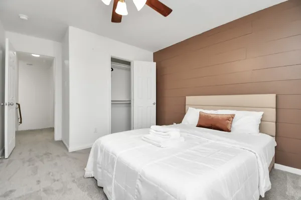 a bedroom with a bed and painting on the wall