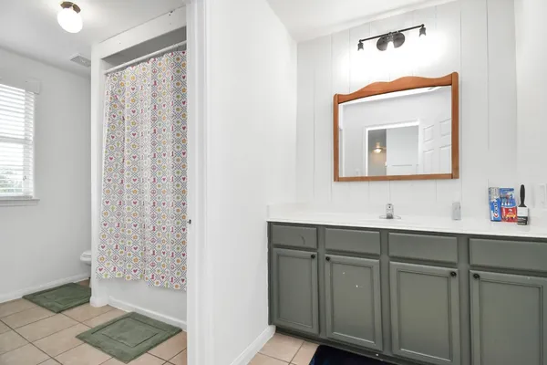 a bathroom with a sink a toilet a mirror and shower