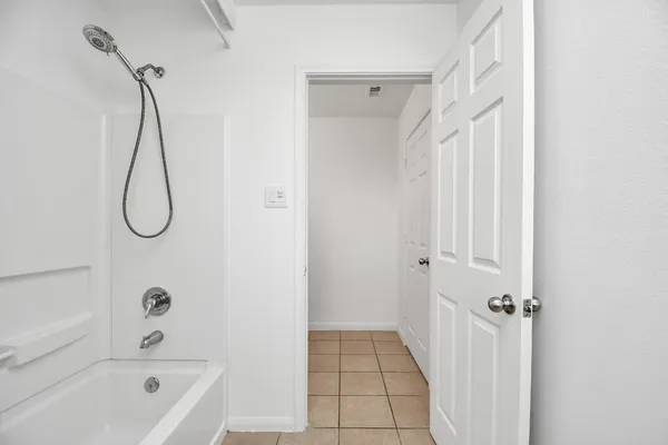 a bathroom with a bath tub with a shower