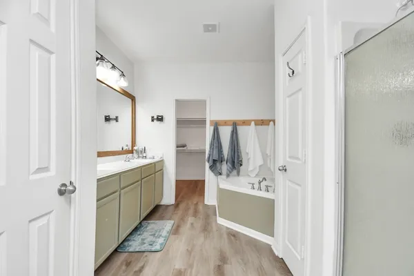 a bathroom with a sink mirror and a bathtub