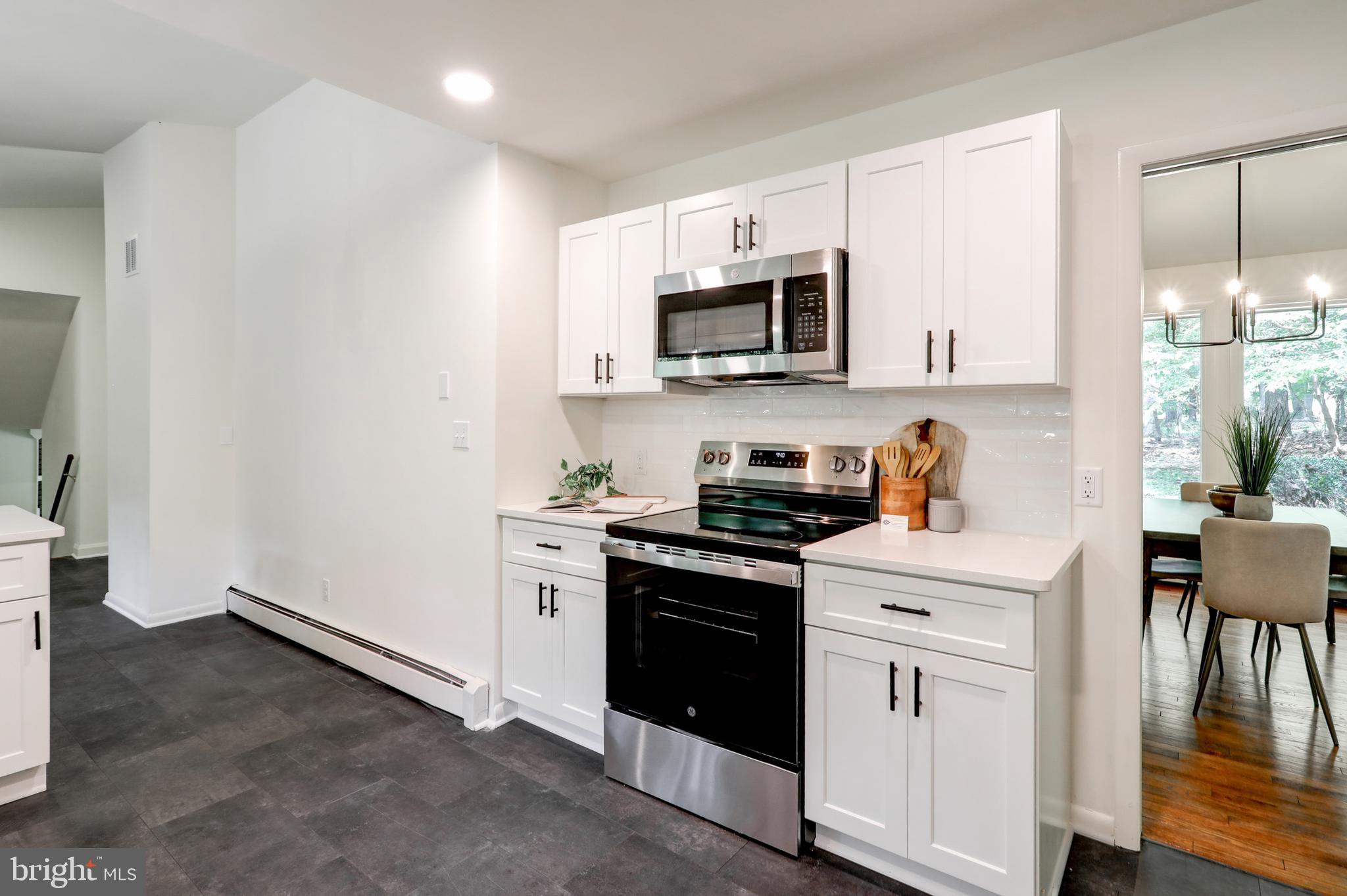 1254 Pinch Valley Road Westminster, MD 21158 - Photo 17 of 45 a kitchen with stainless steel appliances granite countertop a stove top oven a sink dishwasher and white cabinets with wooden floor