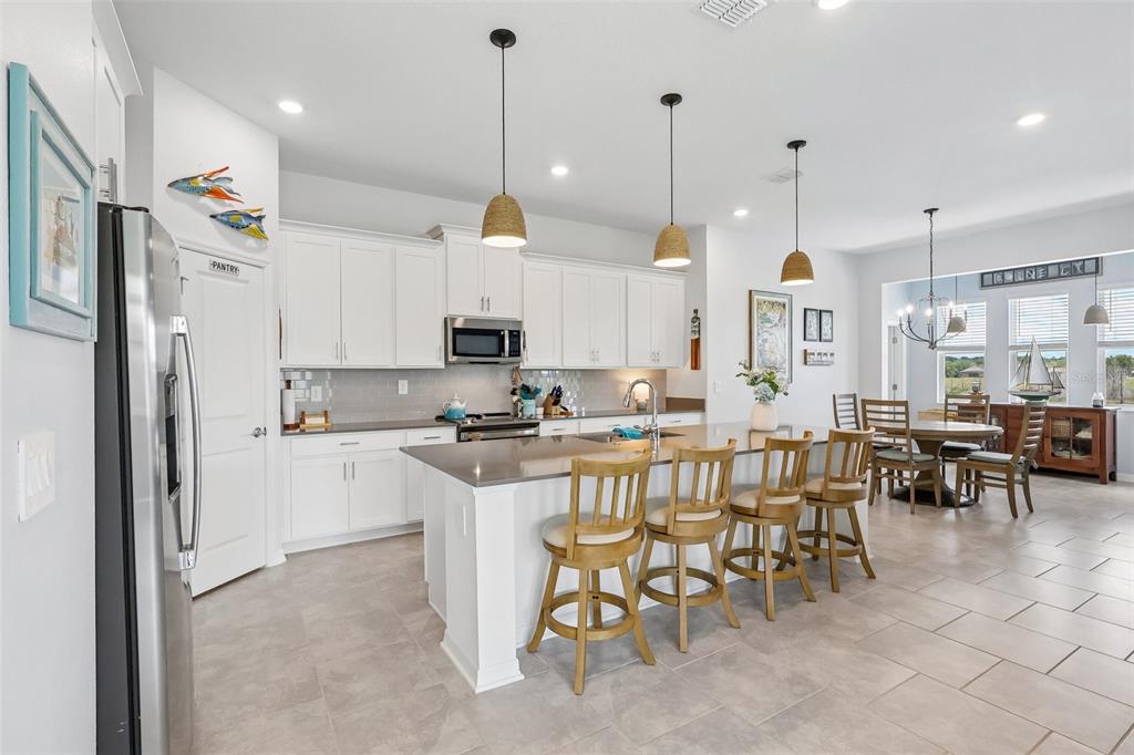 6049 Claystone Way Mount Dora, FL 32757 - Photo 13 of 55 a large kitchen with lots of furniture a sink a dining table and chairs