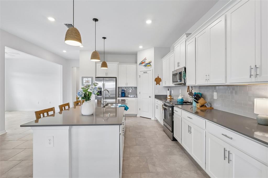 6049 Claystone Way Mount Dora, FL 32757 - Photo 14 of 55 a kitchen with stainless steel appliances granite countertop a sink a stove and a refrigerator