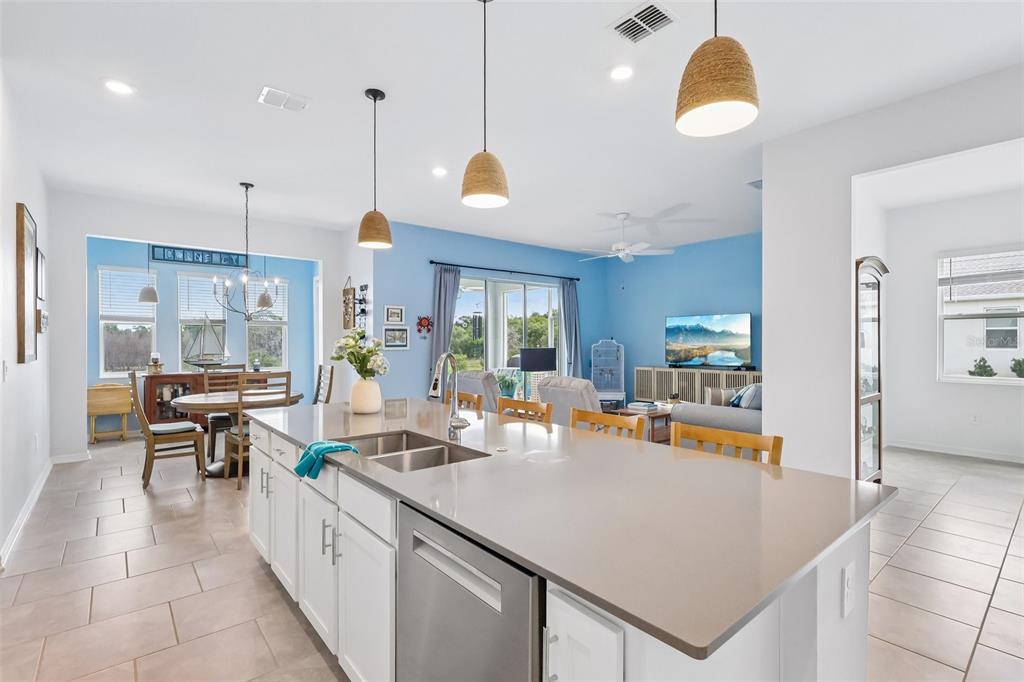 6049 Claystone Way Mount Dora, FL 32757 - Photo 15 of 55 a kitchen with a table chairs and white cabinets