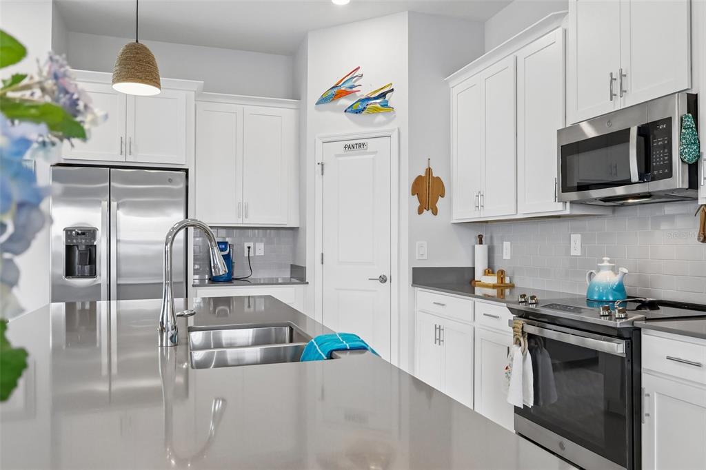 6049 Claystone Way Mount Dora, FL 32757 - Photo 17 of 55 a kitchen with stainless steel appliances granite countertop a refrigerator a stove and a sink