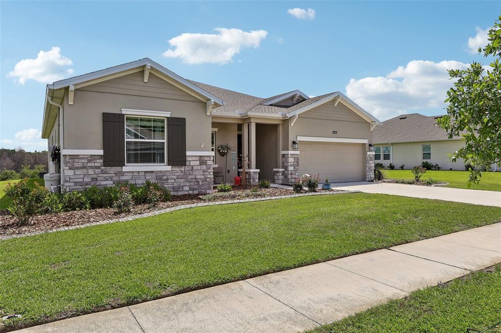6049 Claystone Way Mount Dora, FL 32757 - Photo 3 of 55 a front view of a house with a yard and outdoor seating