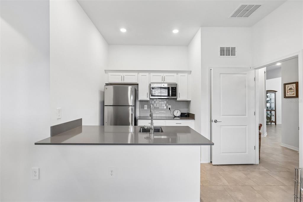 6049 Claystone Way Mount Dora, FL 32757 - Photo 31 of 55 a kitchen with stainless steel appliances granite countertop a refrigerator and a stove
