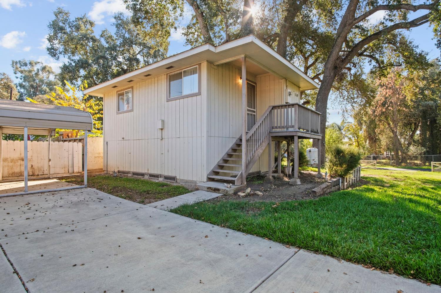 825 Wetherbee Avenue Manteca, CA 95337 - Photo 11 of 22 a view of a house with a yard and a large tree