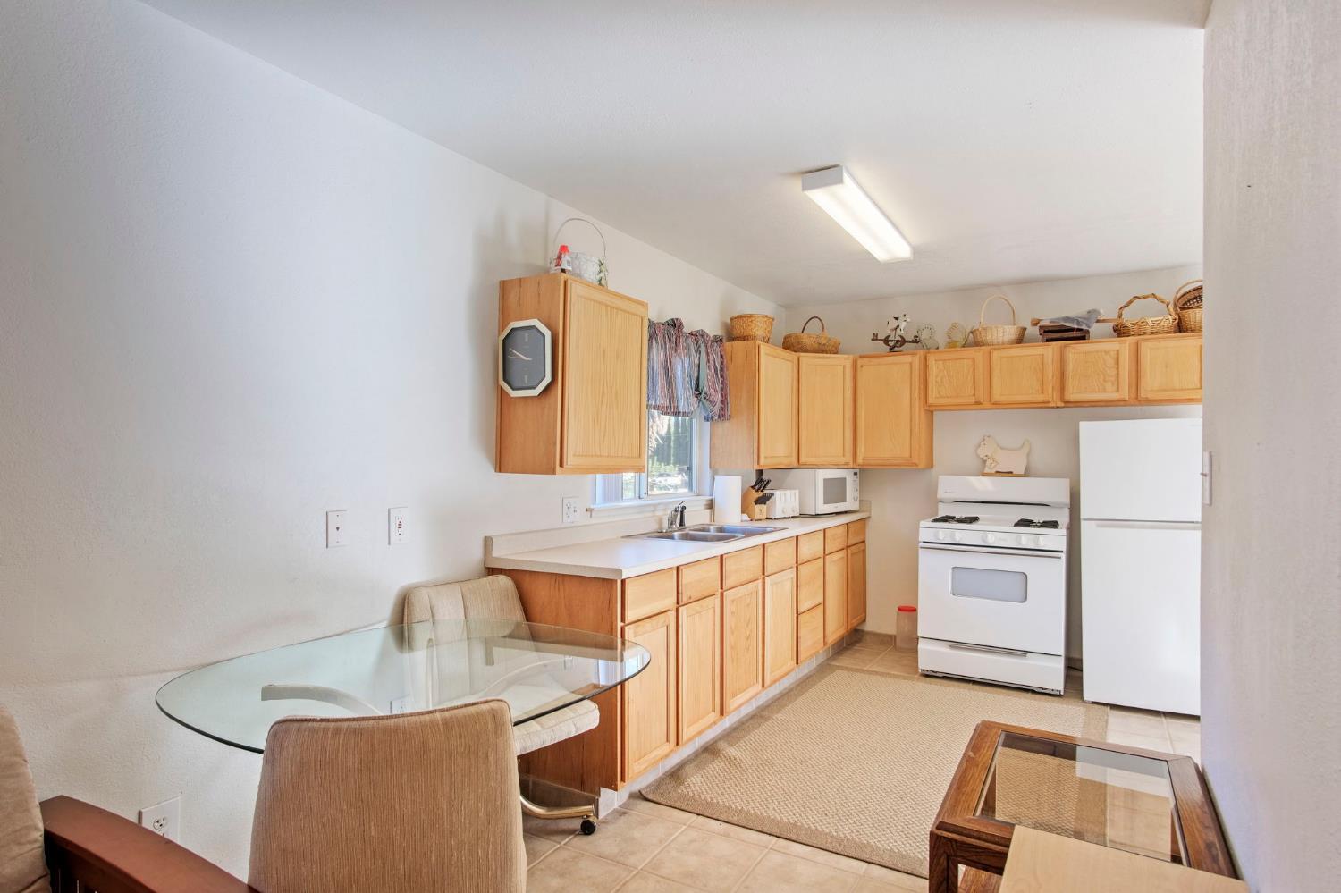 825 Wetherbee Avenue Manteca, CA 95337 - Photo 3 of 22 a kitchen with a sink stove and refrigerator