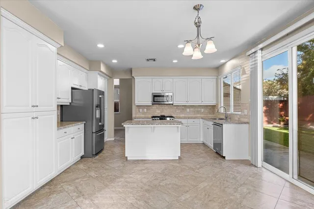 a kitchen with granite countertop a sink a stove and cabinets