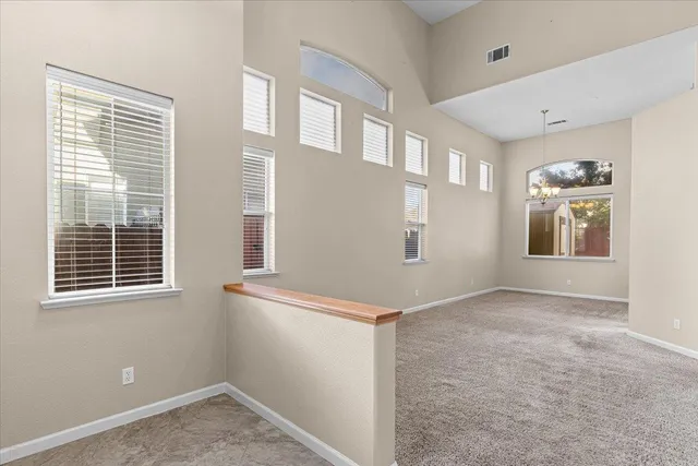a view of an empty room with stairs and a window