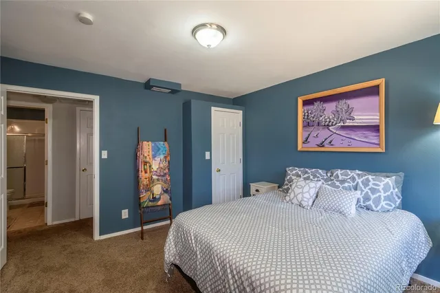 a bedroom with a bed and a painting on the wall